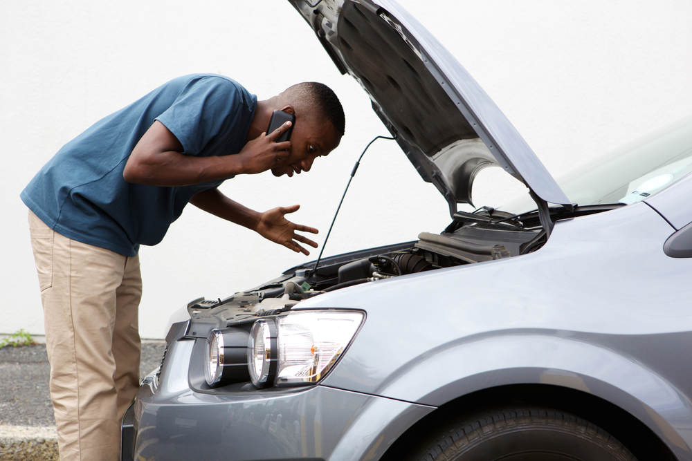 man having trouble with his broken car