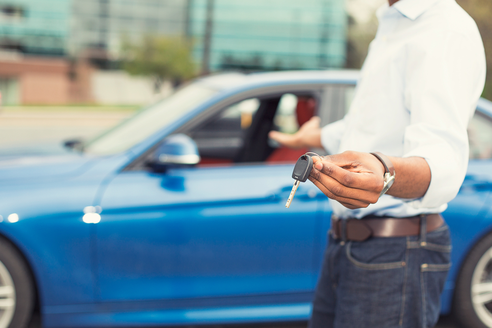 male hand holding car keys