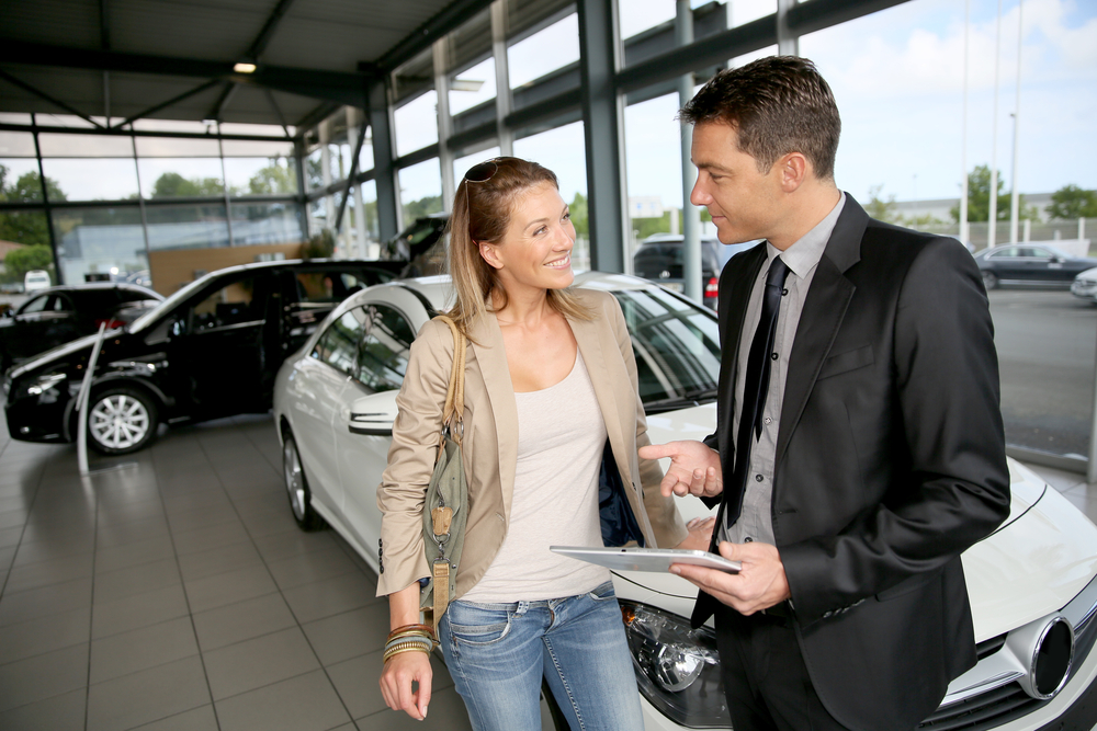 car dealer showing vehicle to woman