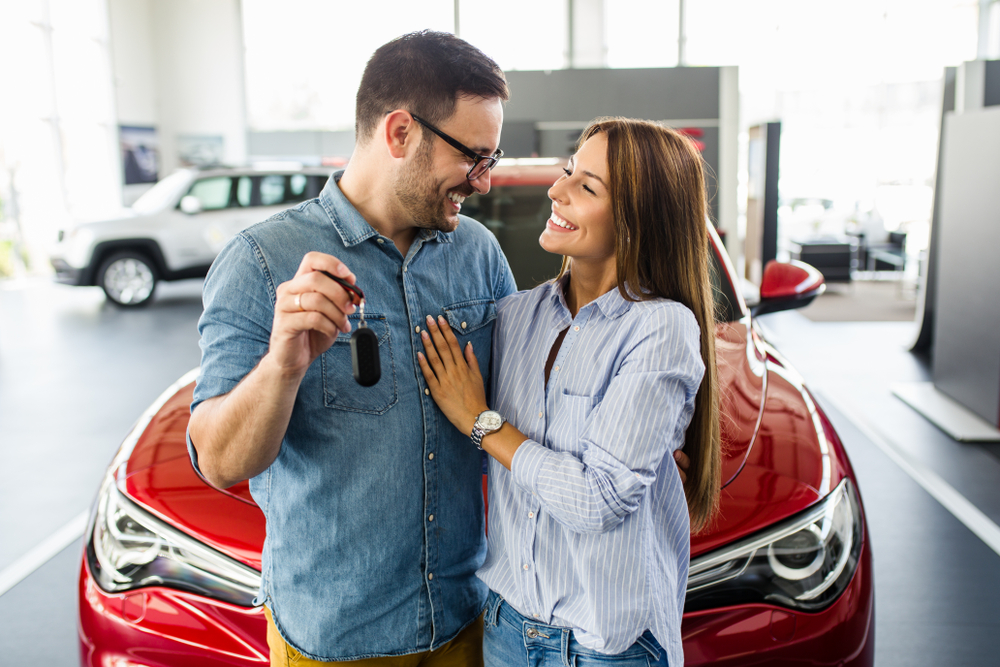 couple holding a key of their new car